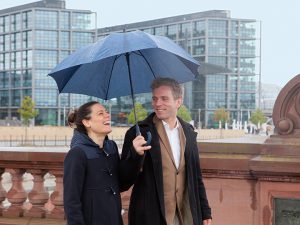 Teaser Paar lachend Brücke Regenschirm
